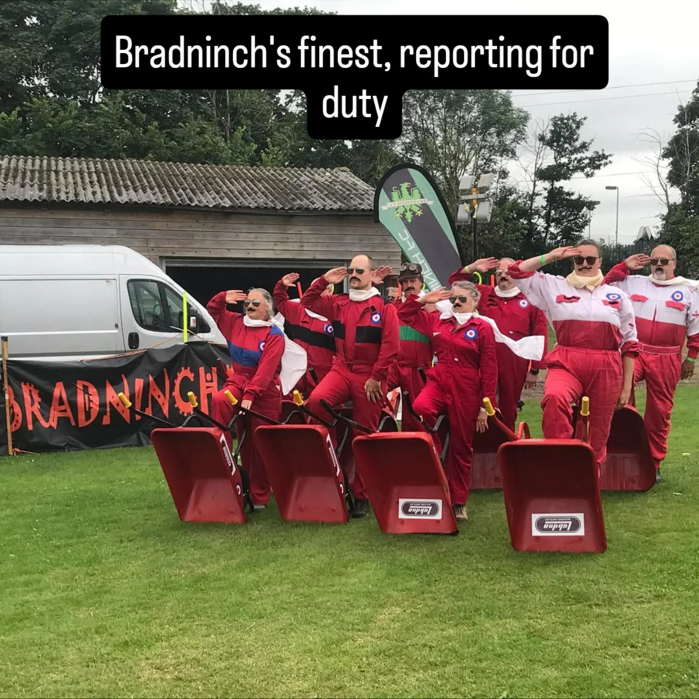 Team saluting with wheelbarrows at Bradninch